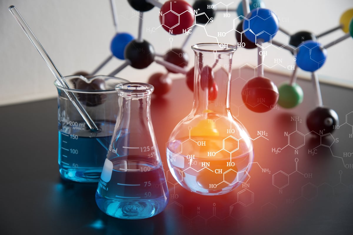 Laboratory glassware with blue liquid, molecular model, and chemical structure overlay