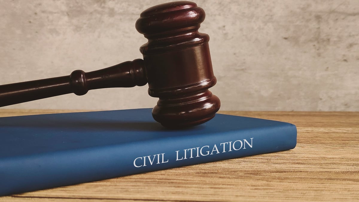 Gavel and a book titled CIVIL LITIGATION on a wooden table