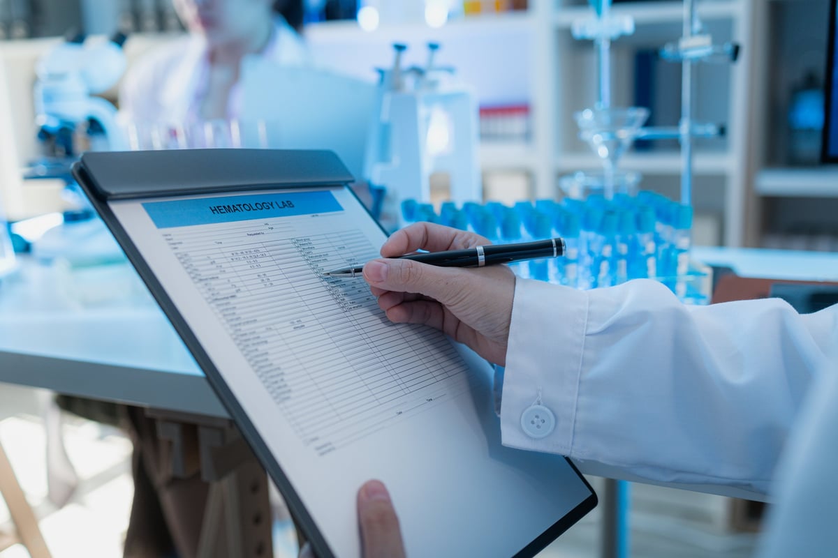 A close-up view of a scientist reviewing hematology lab data